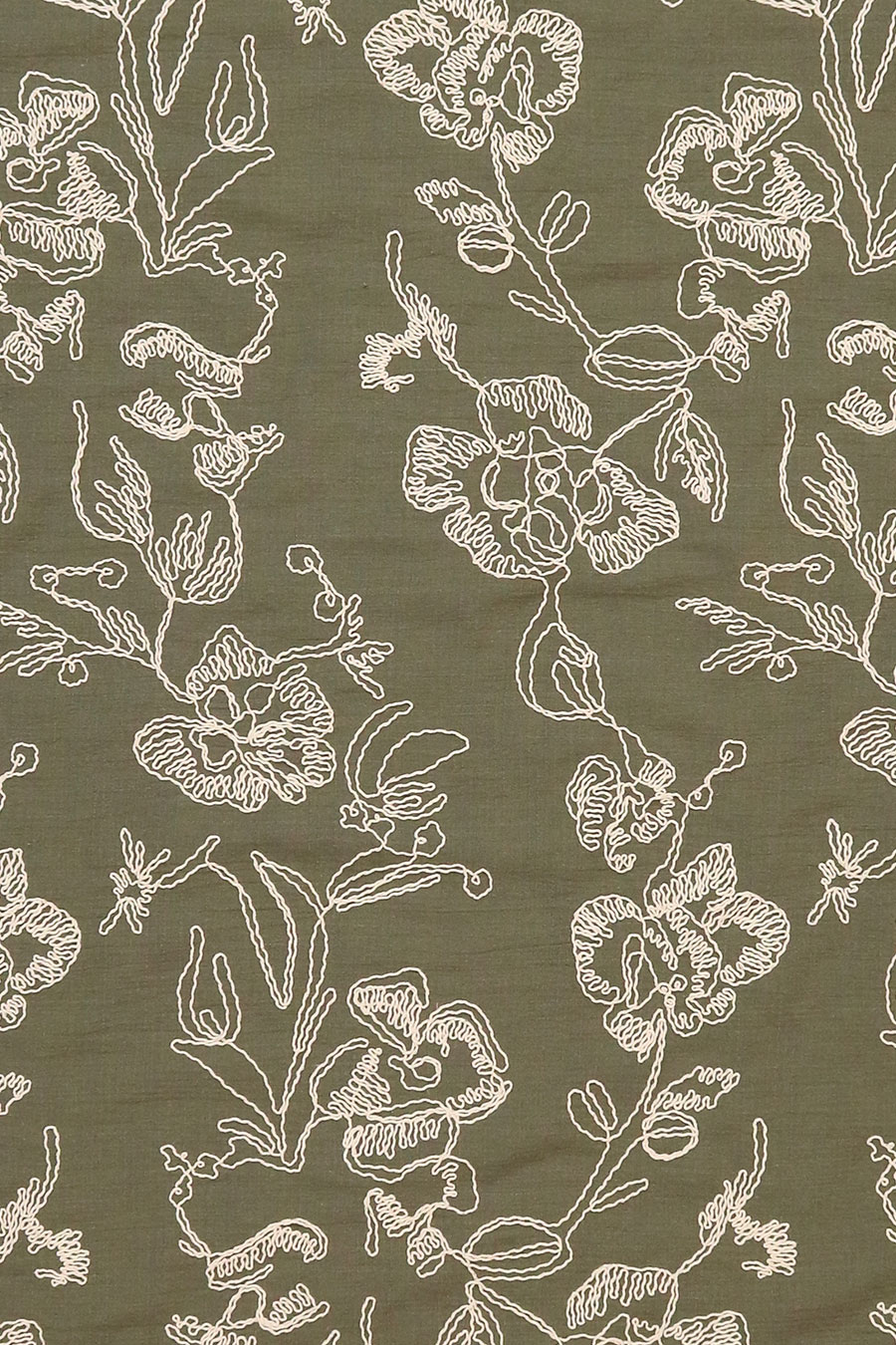 Close-up of ivory cotton cord embroidery on an olive green rayon ground